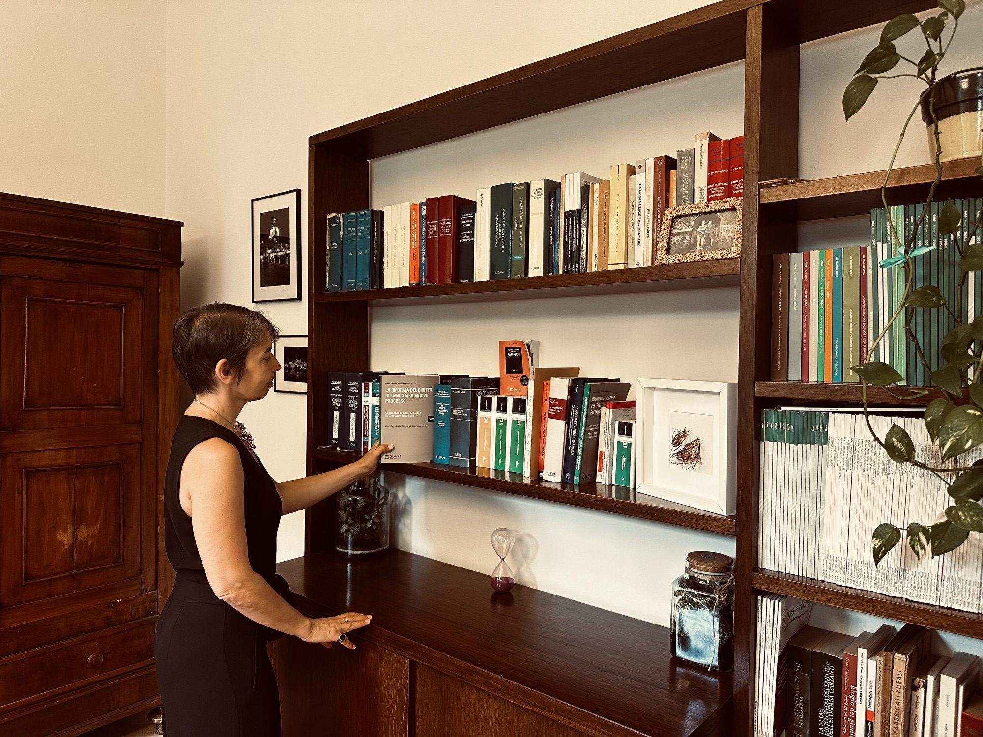 Avv. Paola Spadini nel suo studio, davanti alla libreria dei codici giuridici