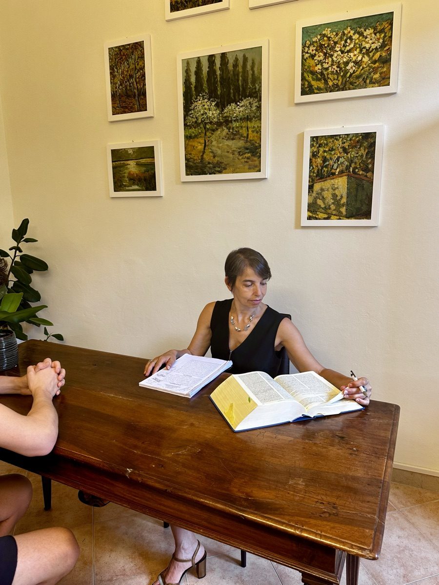 Avv. Paola Spadini consulta il codice durante un colloquio